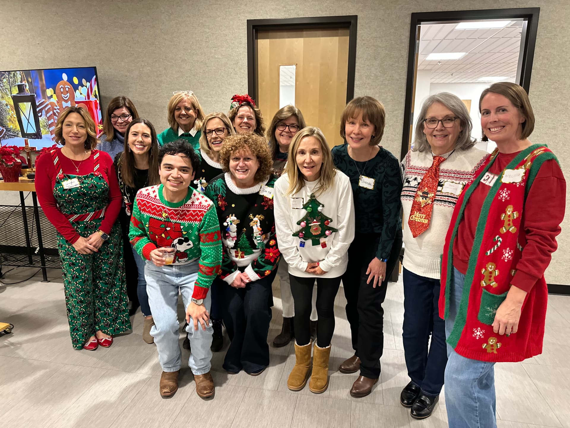 Group photo of members in ugly Christmas sweaters at the party