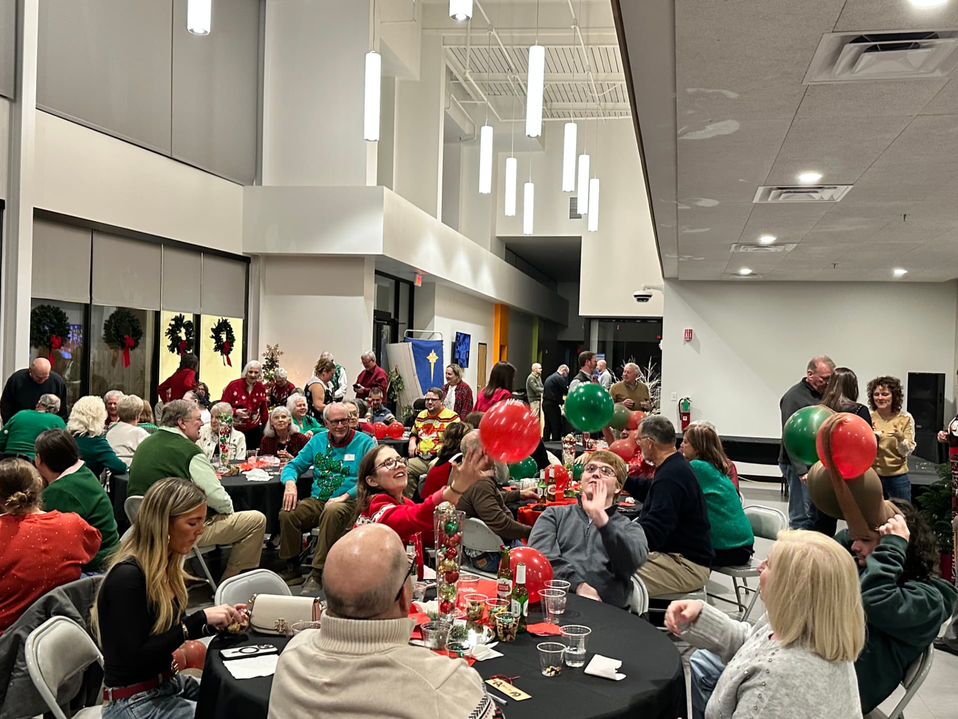 Members in Christmas sweaters celebrating with balloons at the CTR Christmas party